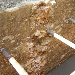 Obr. 42: Valtice – zámek 2004 (akce č. 2004/12) – statické zajištění opěrné zdi – I. etapa – JZ část - záchranný výzkum. Detail zbytků kamenocihelného pilíře ve střední části výkopu – pohled od J (foto P. Vitula).