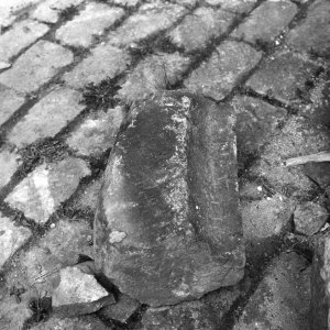 Obr. 43: Veveří - hrad 1980. Obnova kanalizace. Druhotně přemístěný nález části kamenného klenebního žebra (foto L. Konečný).