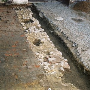 Obr. 54: Veveří - hrad 2000. Sondáž pro SHP. Sonda č. 2. Relikty základového kamenného zdiva středověkého stáří jsou pozůstatkem zaniklého paláce při SV straně arkádového nádvoří. Nejstarší relikty zdí se nacházely v SZ části sondy, kde prostor mezi nimi byl vyplněn sytě černým zásypem se stopami pyrotechnických činností a keramikou ze 14. stol. Mezi arkádami a základovým zdivem je cihelná pálená barokního stáří (foto P. Vitula).