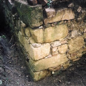 Obr. 64: Veveří - hrad 2002. Průzkum a dokumentace reliktů zdiva mezi věžemi hranolovou a prachovou. Od 80. let minulého stol. zůstaly odkryty relikty kamenného středověkého zdiva s bránou na vnější straně současné JV hradby. Jejich zbytky byly začištěny, zdokumentovány a přesně zaměřeny (foto P. Vitula).