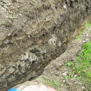 Obr. 113: Veveří – hrad 2015. Vodovod. Profil výkopu pro vodovodní potrubí s výchozem skalního podloží v prostoru středního hradu – pohled od SV (foto P. Vitula).