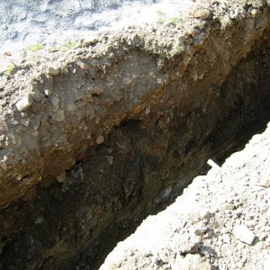 Obr. 122: Veveří – hrad 2015. Vodovod. Novověké a recentní souvrství v profilu výkopu pro vodovodní potrubí v S části  přihrádku před dílnou – pohled od SV (foto P. Vitula).