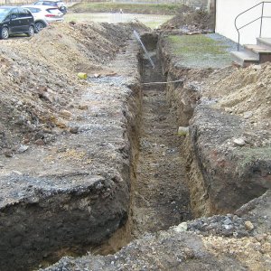 Obr. 221: Veveří – hrad 2021. Páteřní rozvody elektřiny. Výkopy v Z části přihrádku před kovárnou s raně středověkou vrstvou z 1. pol. 13. stol.– celkový pohled od SV (foto P. Vitula).