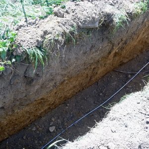 Obr. 227: Veveří – hrad 2021. Páteřní rozvody elektřiny. Profil výkopu na předhradí s ojedinělými novověkými zlomky keramiky – pohled od JZ (foto P. Vitula).