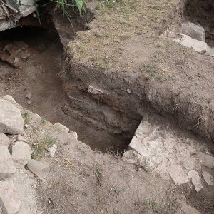 Obr. 239: Veveří – hrad 2022. Jižní brána a skleníky – zjišťovací sondáž č. 2. Situace v sondě č. 2  – výkopem byla odkryta černošedá hliněná dorovnávka terénu, na J konci zesílená část kamenného tarasu a na S konci pak klenební oblouk se sutí – pohled od J (foto P. Vitula).
