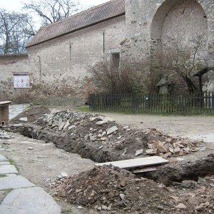 Obr. 71: Pernštejn – hrad 2007/1. Suchovod. Výkop na 5. nádvoří hradu porušil pod vrstvou hlinitokamenité dorovnávky relikty dlažby tvořené plochými kameny střední a větší velkosti – pohled od Z (foto P. Vitula).