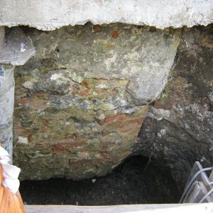 Obr. 28: Milotice 2010. Zámecká jízdárna – dešťový odpad – JZ část uvnitř – detail výkopu pro potrubí s reliktem smíšeného kamenocihelného základového zdiva pravděpodobně renesančního stáří – pohled od SV (foto P. Vitula).
