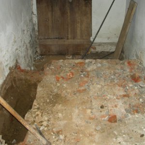 Obr. 61: Milotice 2005. Stará pošta – odvlhčení – interiérová podlaha místnosti č. 3 s obvodovým výkopem a reliktem cihelné dlažby – pohled od JV (foto P. Vitula).